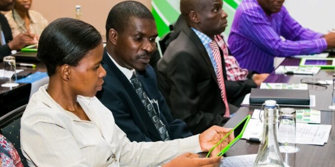 Johannesburg, South Africa- diverse business persons going over data on digital devices at a meeting